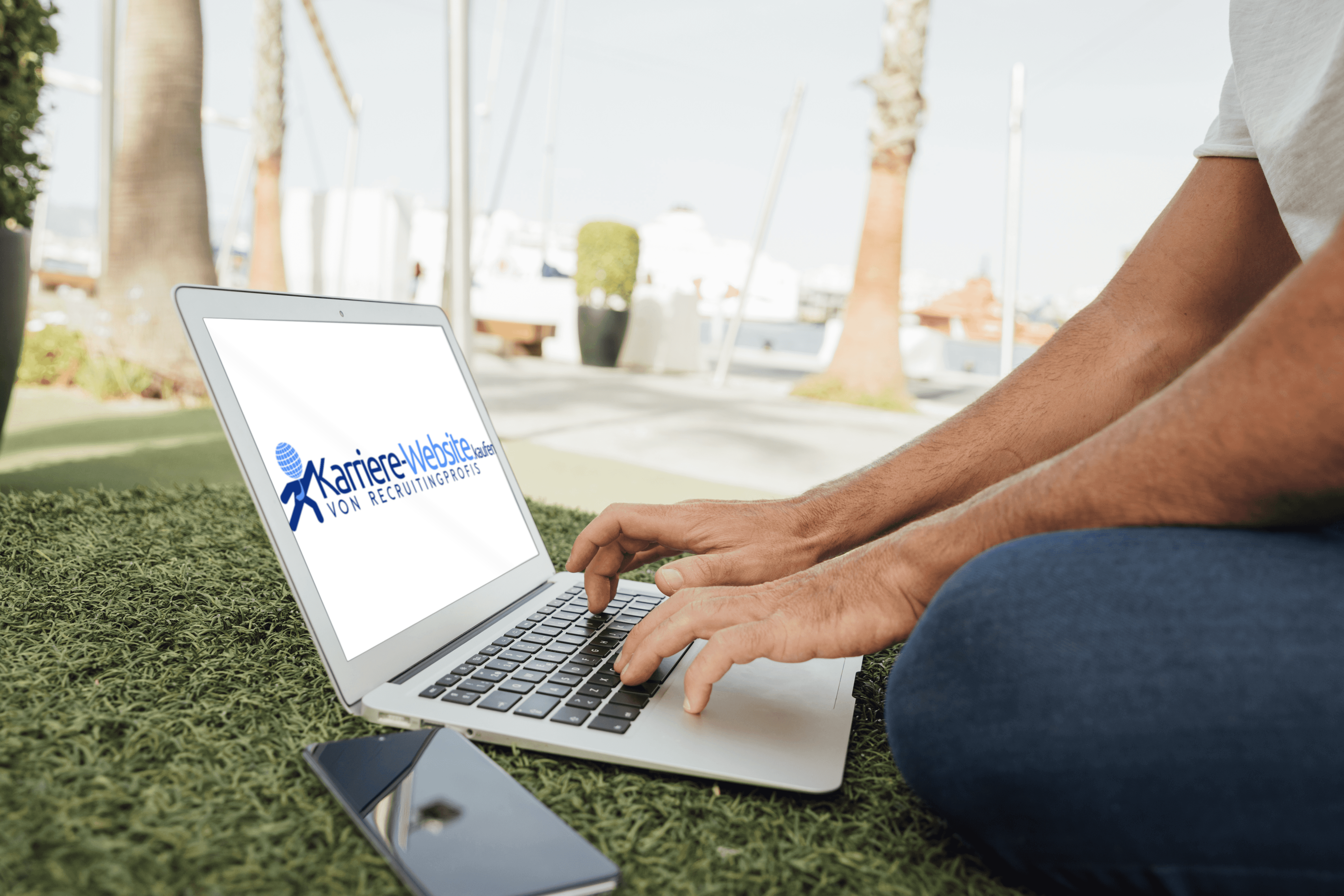 Person sitzt in einem Park mit einem Karriere-Website.kaufen Laptop